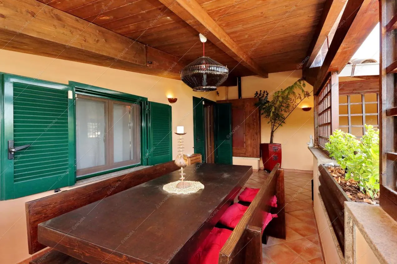 Tavolo da pranzo in legno, lampadario e candelabro in veranda
