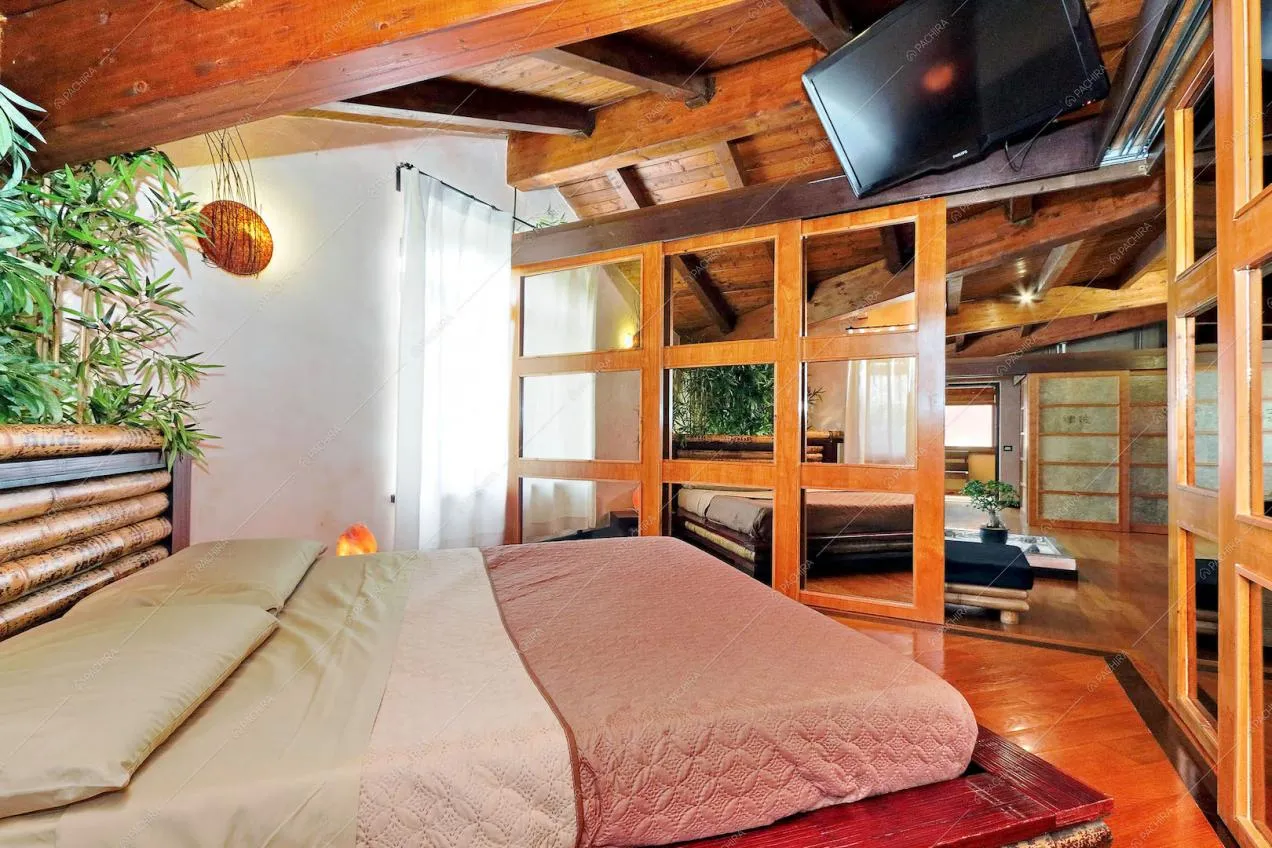 Camera da letto con struttura in legno e porte scorrevoli a specchio