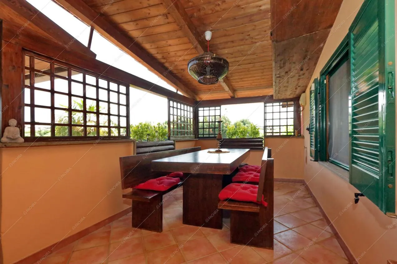 Veranda con tavolo da pranzo in legno