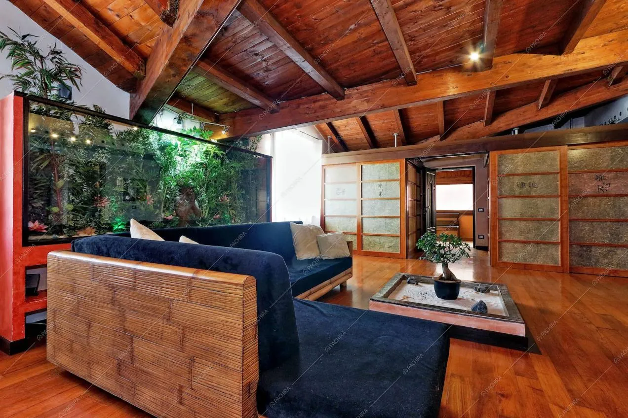 Divano angolare blu e tavolino con sabbia e bonsai