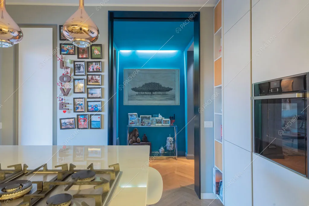 Cucina bianca con isola e fornelli a gas dell'appartamento Molucche, location in stile contemporaneo a Roma