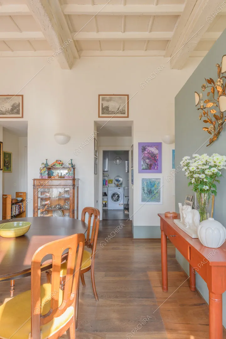 Tavolo da pranzo nella zona living con pavimento in parquet e pareti bianche