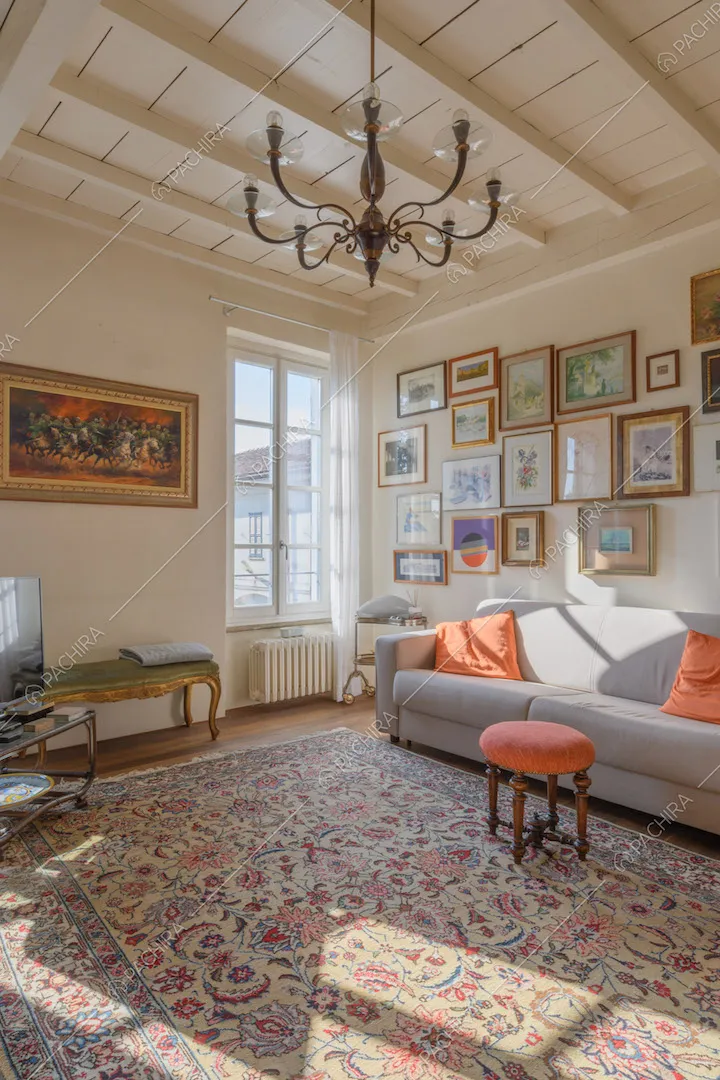 Luminoso salotto con divano grigio, soffitto a cassettoni e pavimento in parquet