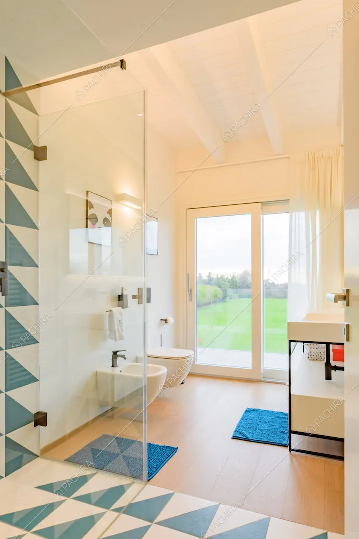 Bagno con piastrelle a triangoli blu e bianchi, pavimento in parquet e vetrata