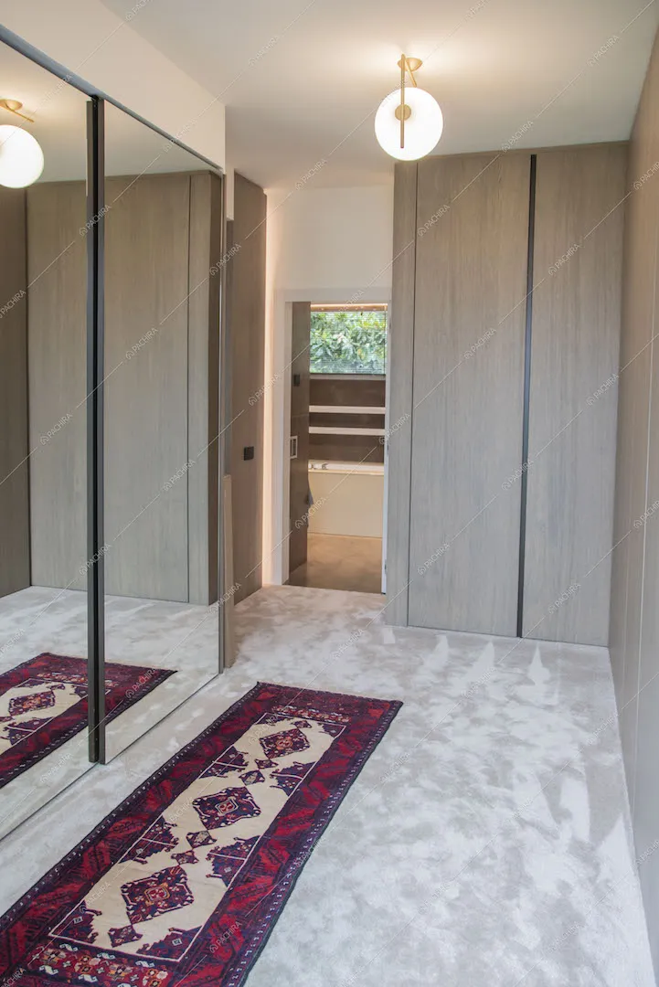 Cabina armadio con moquette sul pavimento e armadio con ante scorrevoli