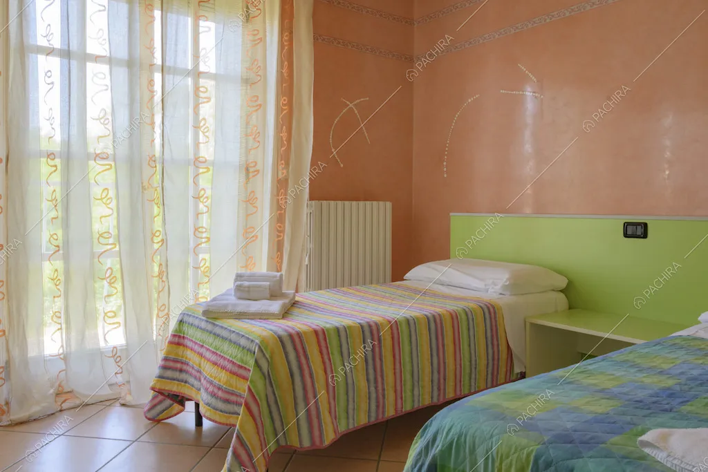 Camera da letto con due letti e tendaggio con decori
