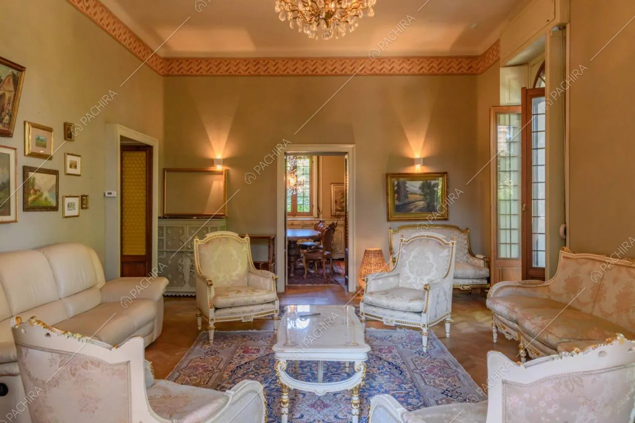 Dal salotto in stile classico vista sulla sala da pranzo con tavolo in legno