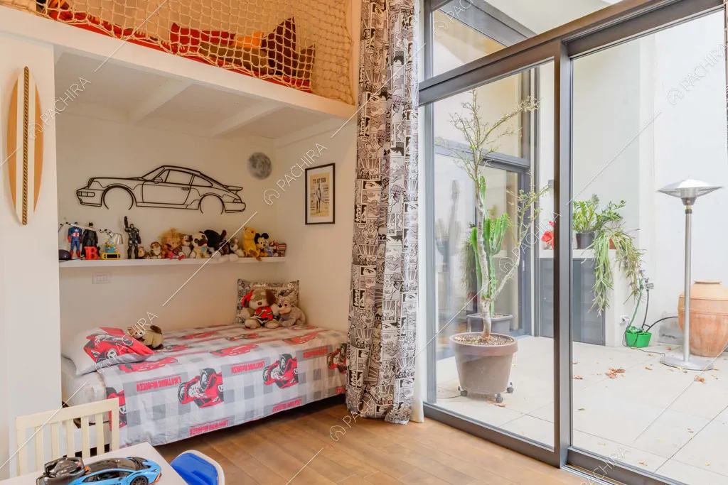 Camera da letto dei bambini con porta-finestra scorrevole e pavimento in parquet