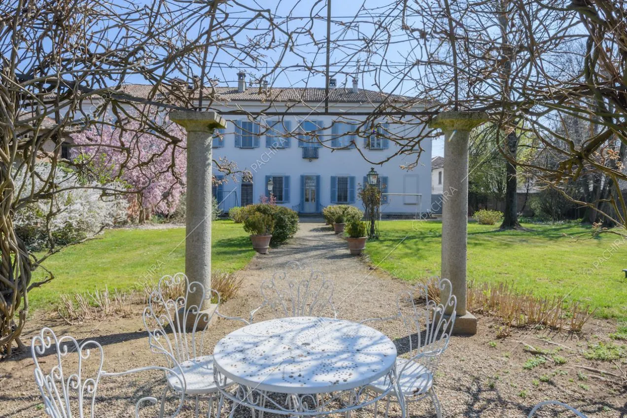 Tavolino e sedie bianchi nel gazebo del cortile