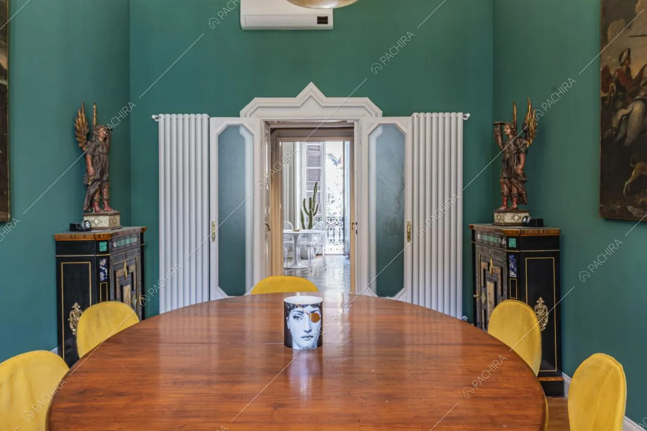 Pareti color ottanio nella sala da pranzo e statue soprammobili