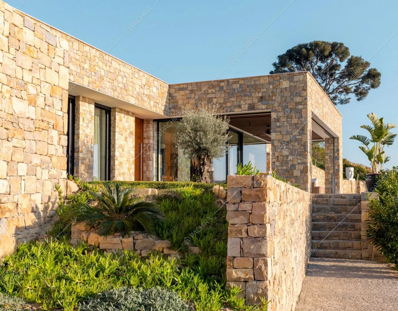 Esterni in pietra e veranda visti dal giardino della location