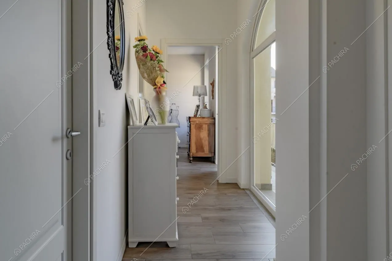 Corridoio con pareti bianche e mobili con oggetti d'arredo