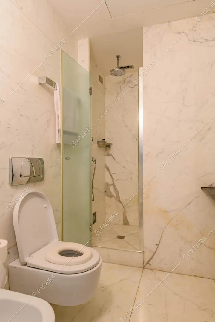 Bagno con box doccia, pavimento e pareti in marmo