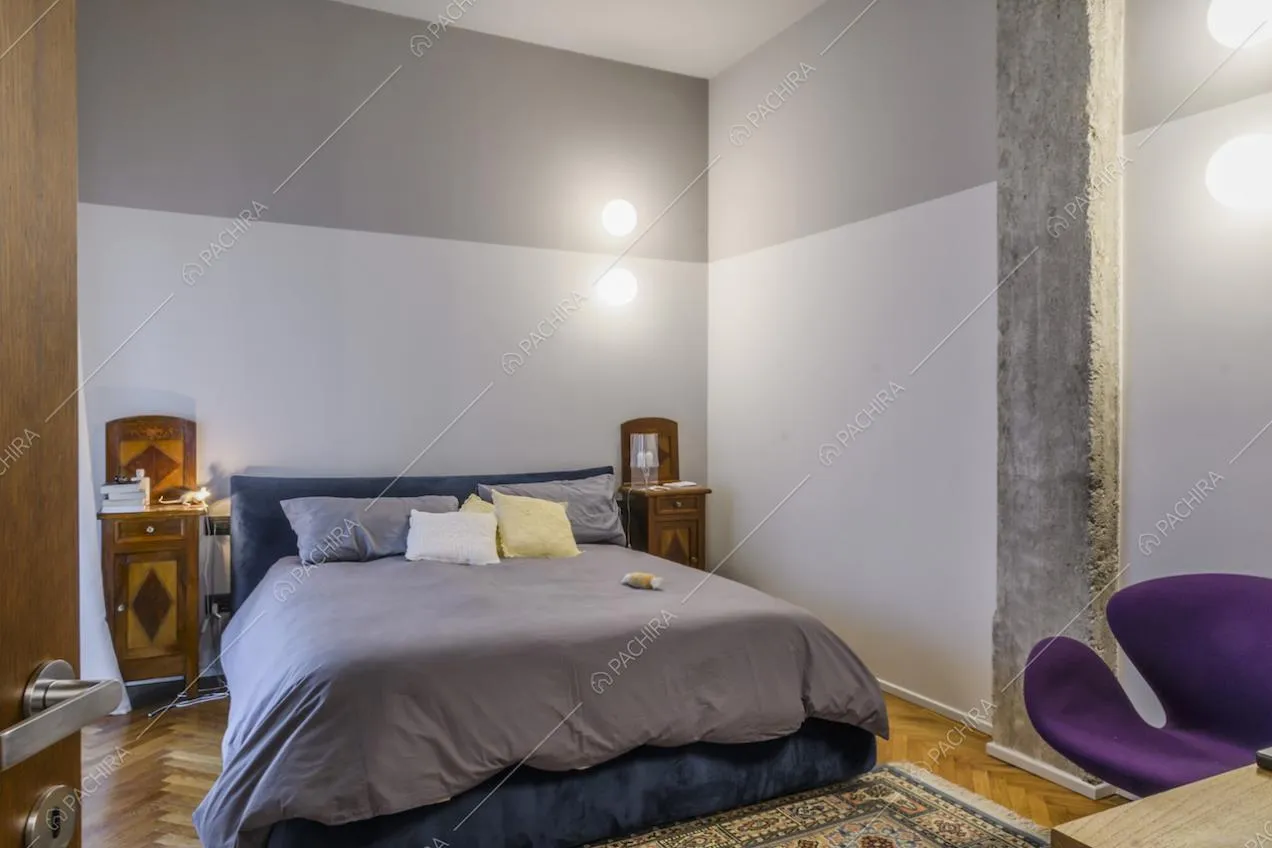 Camera da letto matrimoniale con pareti in toni di grigio