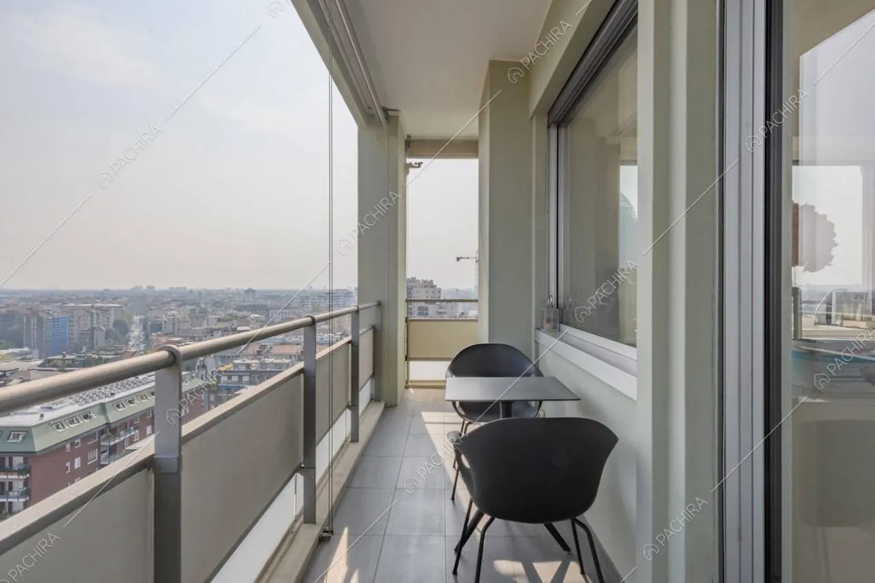 Pavimento in piastrelle grigie e tavolo da esterni nero sulla terrazza