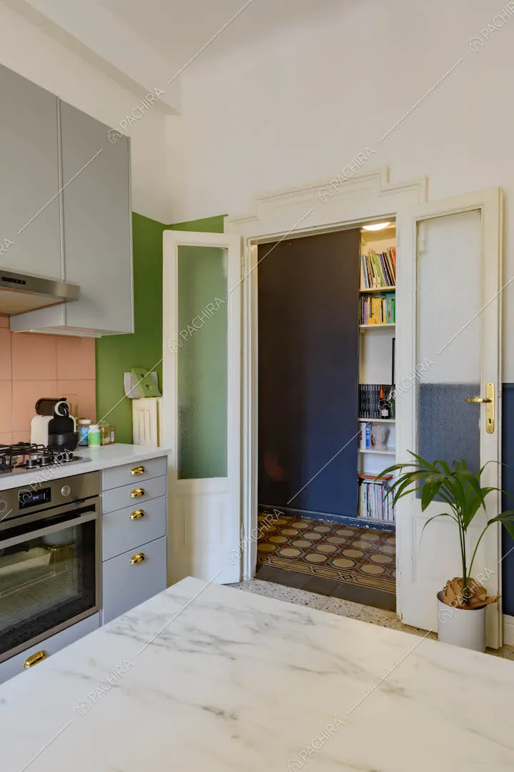 Tavolo da pranzo con piano in marmo nella cucina a parete con paraschizzi rosa
