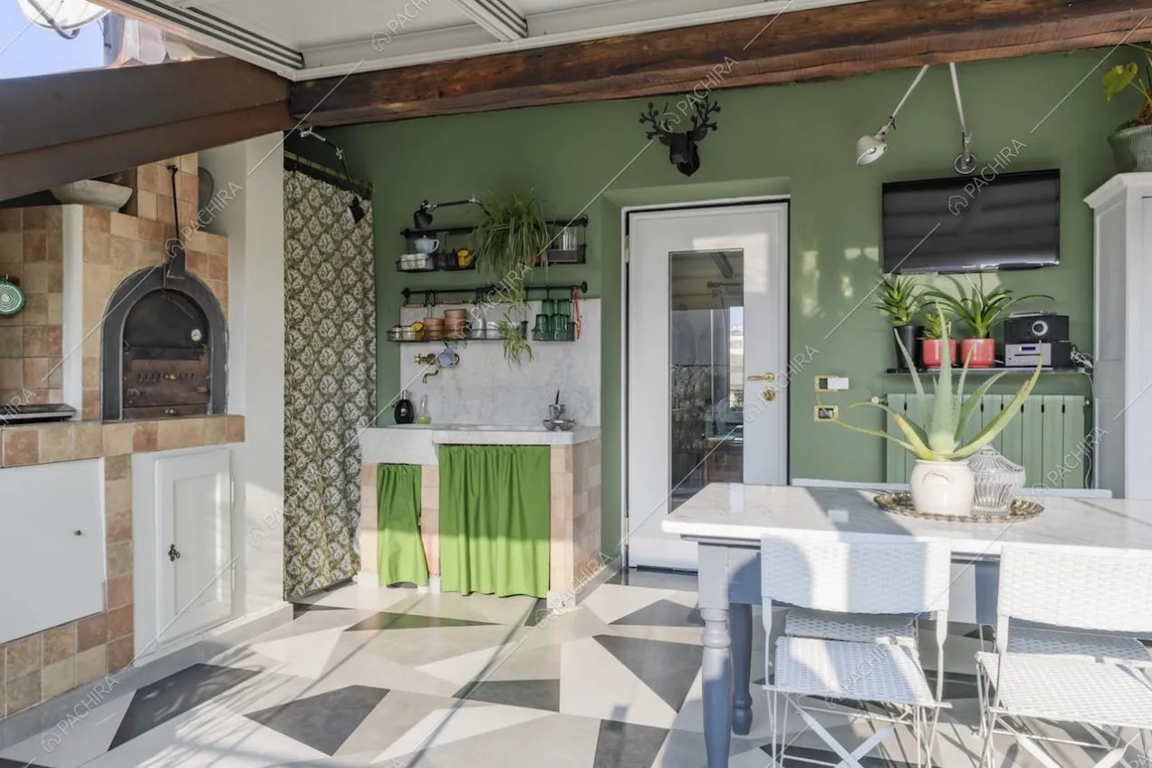 Angolo di veranda con camino, oggetti da cucina e tavolo