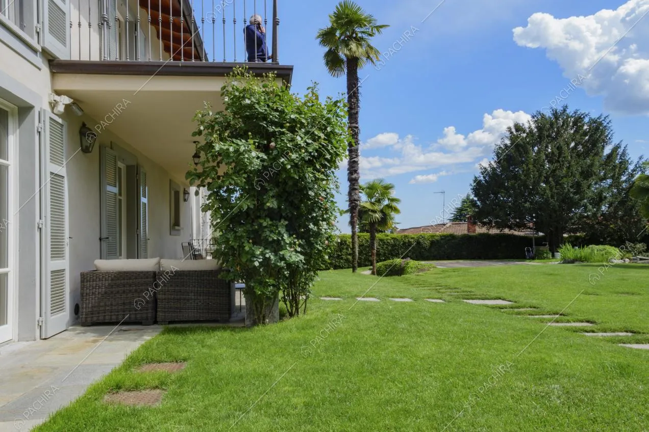 Giadino della location con vialetto in lastre di pietra, veranda e terrazza