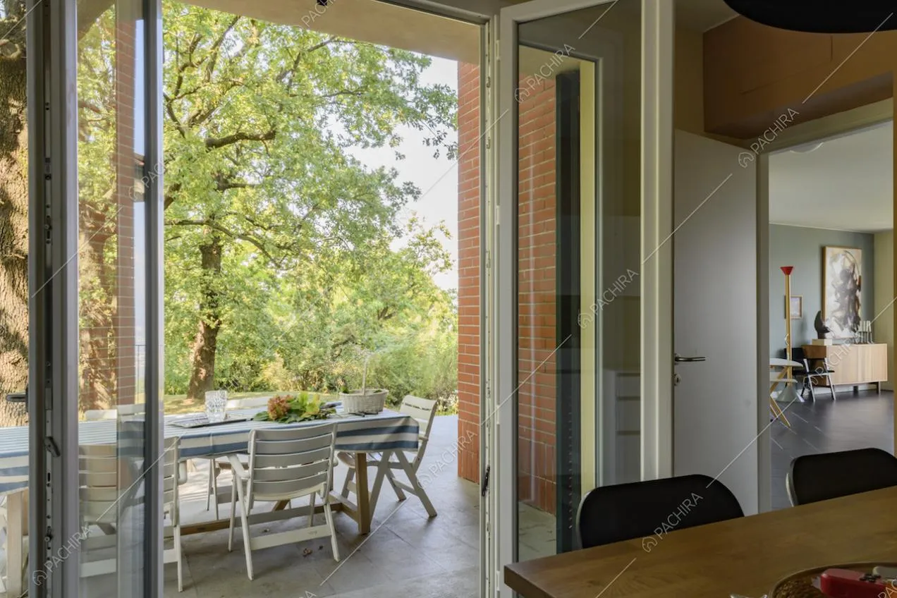 Dalla cucina vista sulla terrazza immersa nel verde e sulla camera attigua