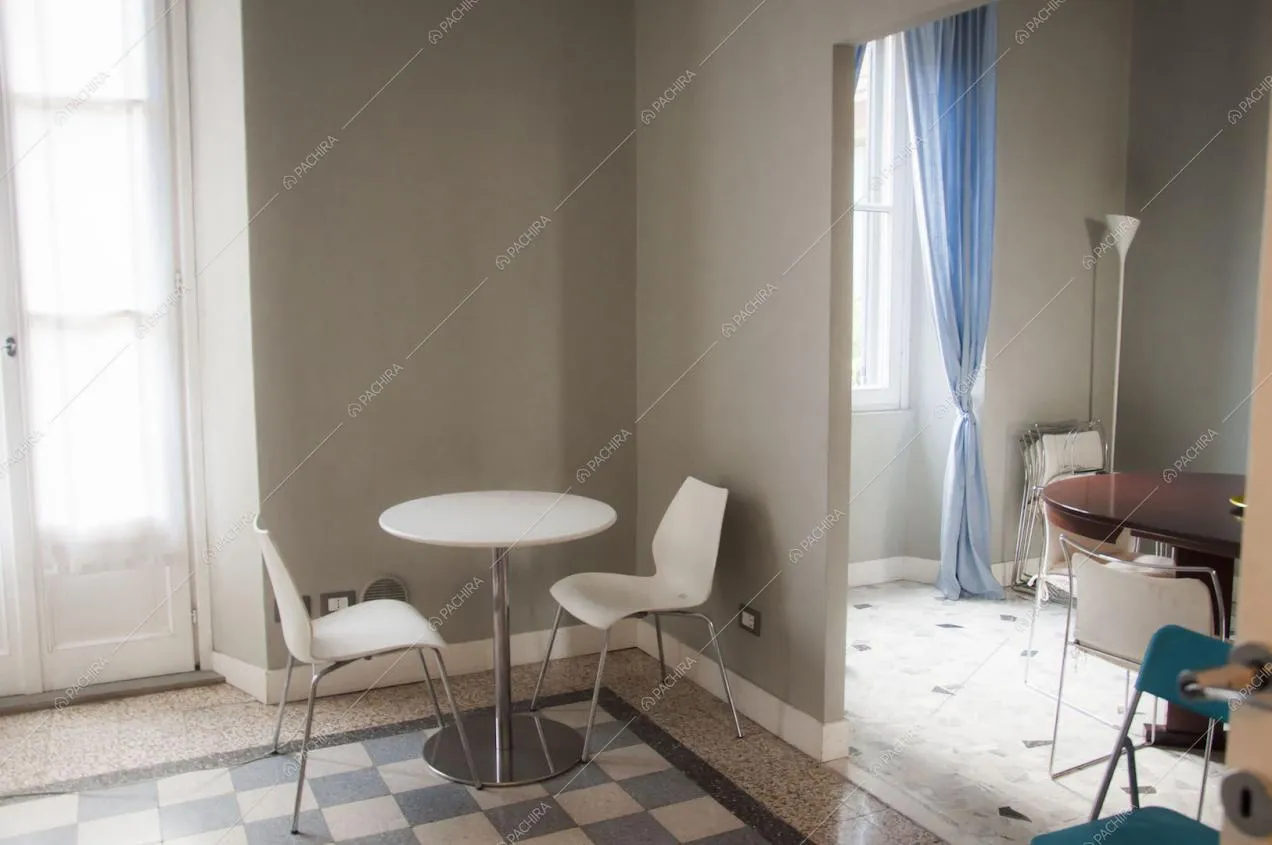 Tavolino bianco in metallo con sedie in cucina e scorcio su zona pranzo