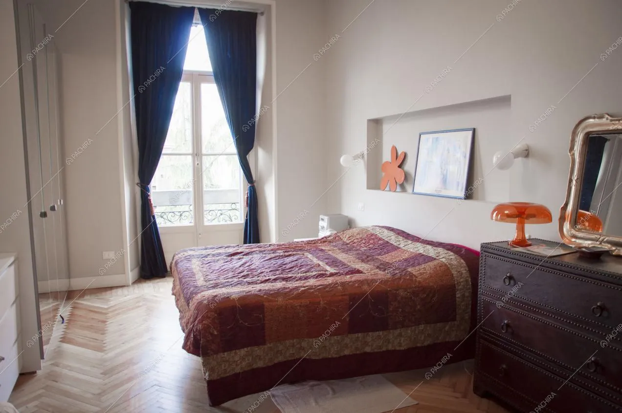 Camera da letto con parquet a lisca di pesce e armadio a specchio