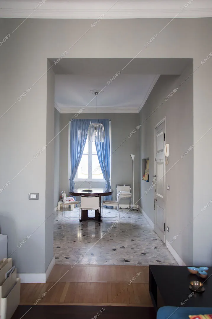 Vista sulla zona pranzo con tavolo rotondo e lampadario in vetro
