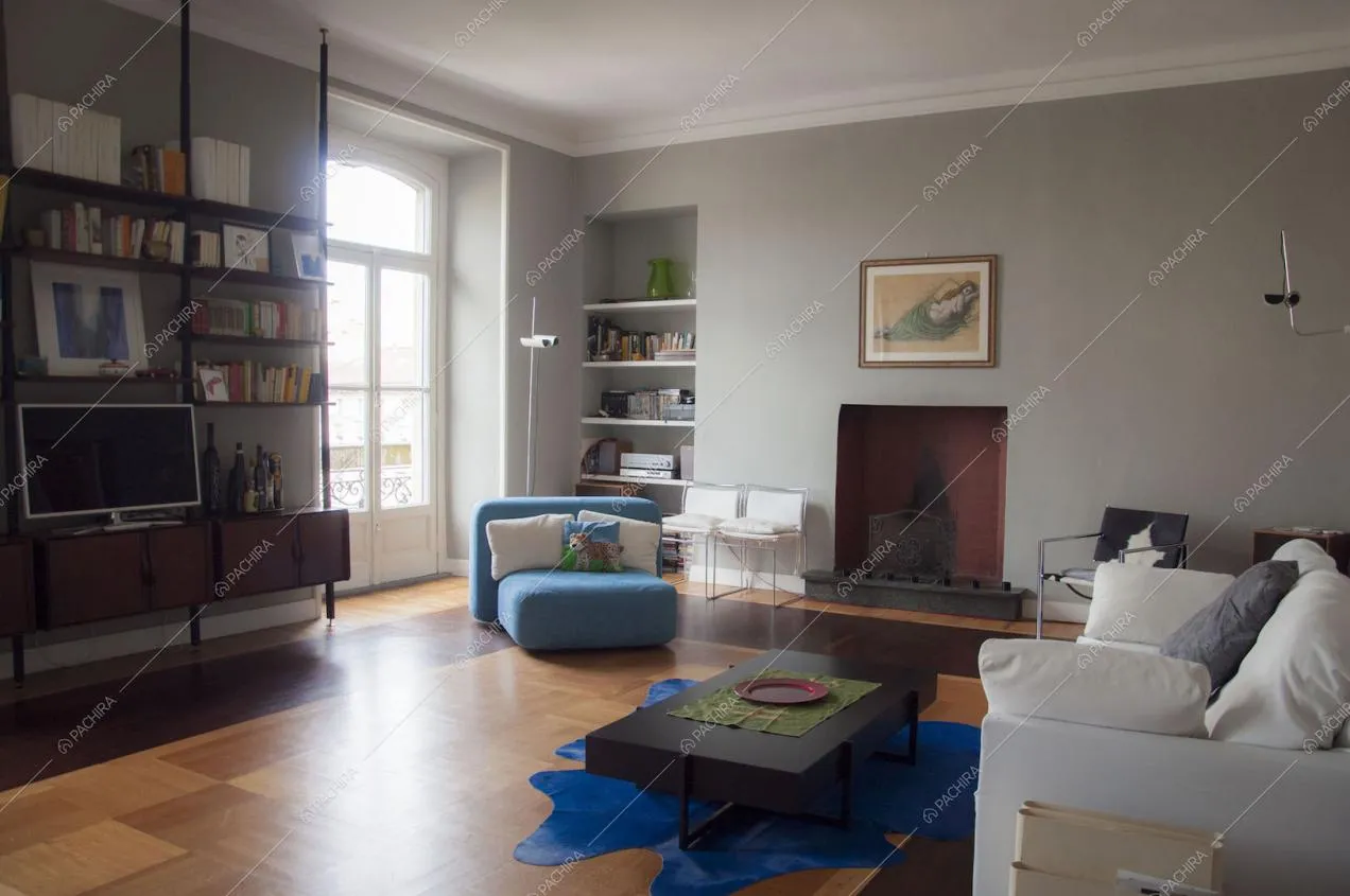 Libreria minimal a parete, divani e pareti in boiserie nella zona living