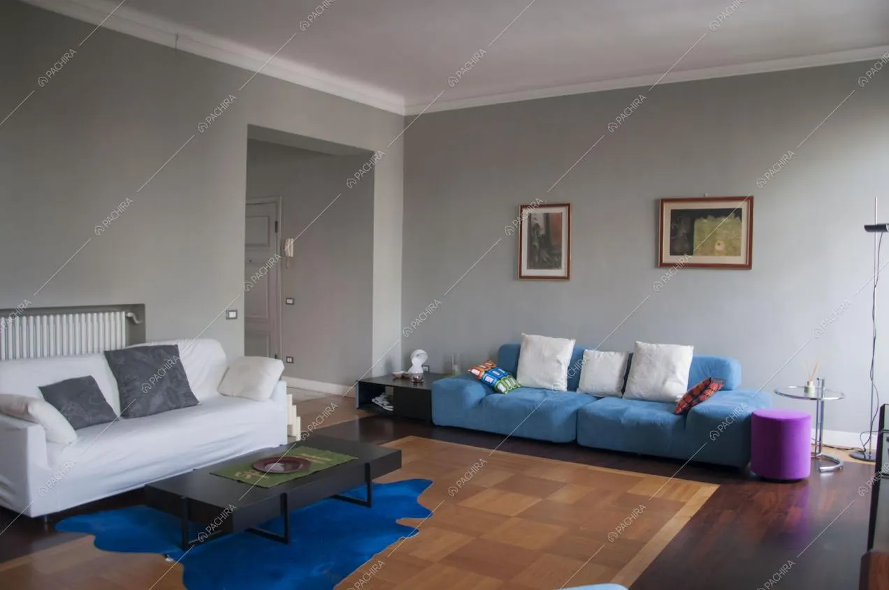 Zona living con pareti grigie e parquet