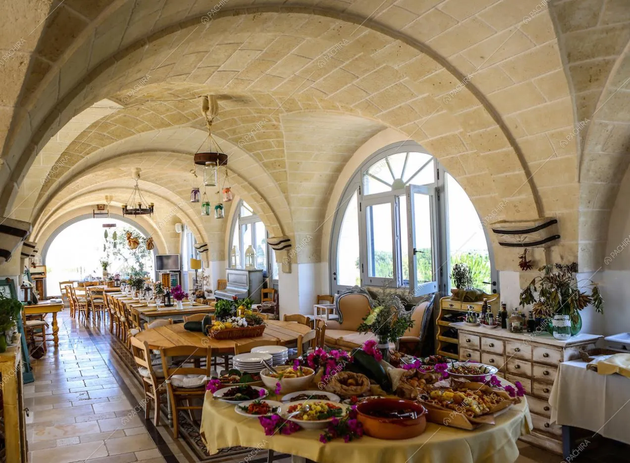 Vista della zona pranzo con quattro tavoli e cassettiera delabré