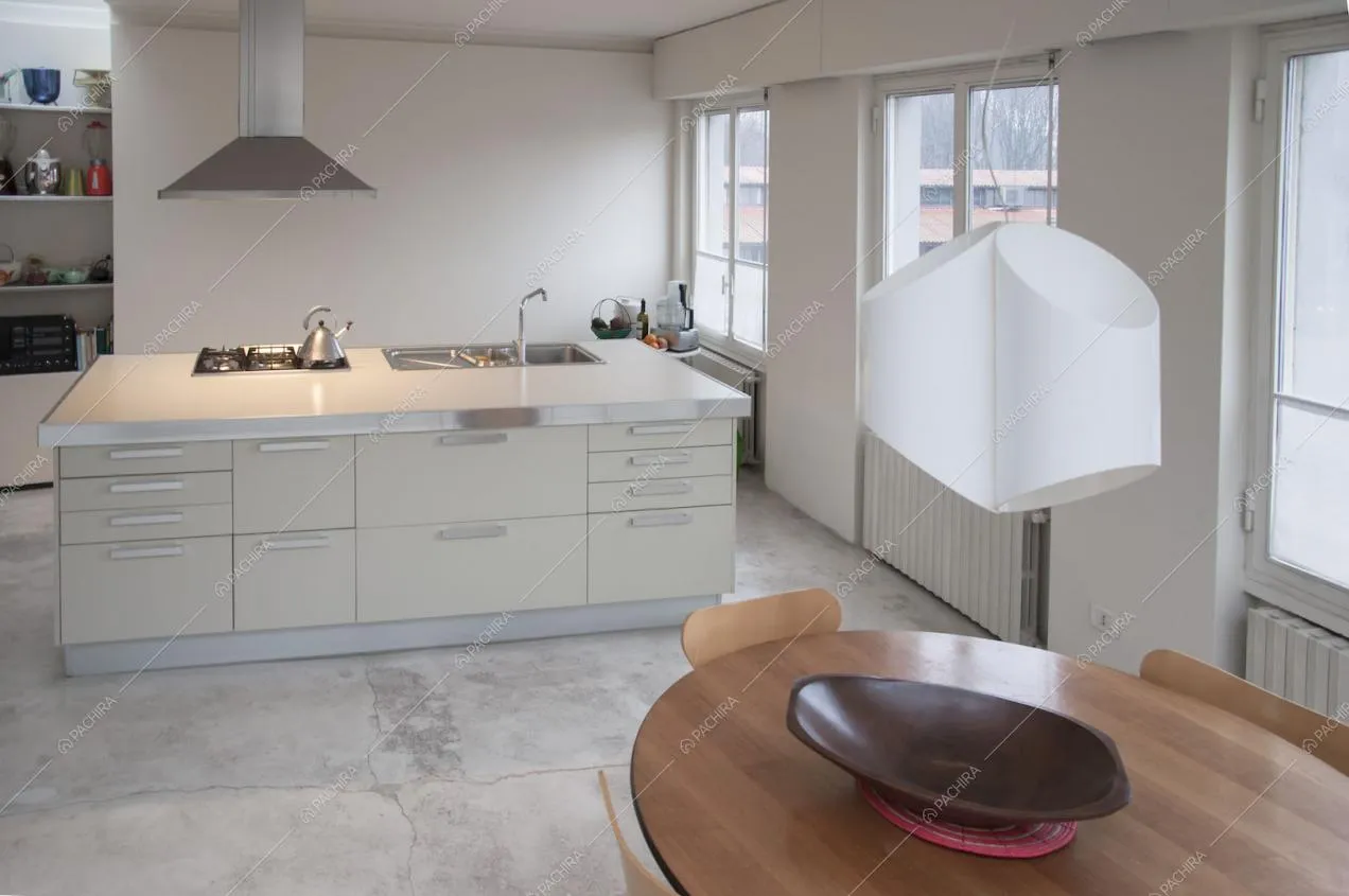 Zona cucina con isola, fornelli a gas e tavolo in legno