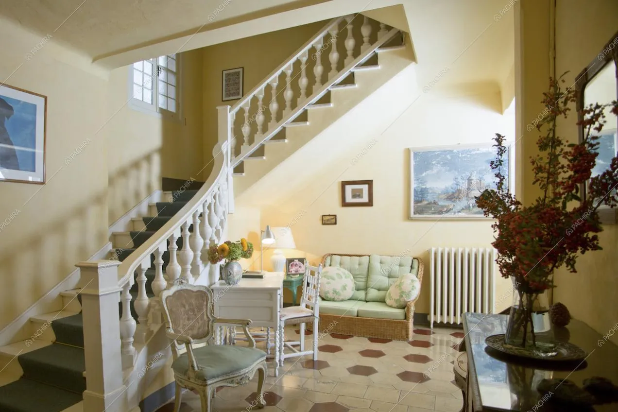 Poltrona d'epoca, divanetto in vimini, scrivania bianca e scale