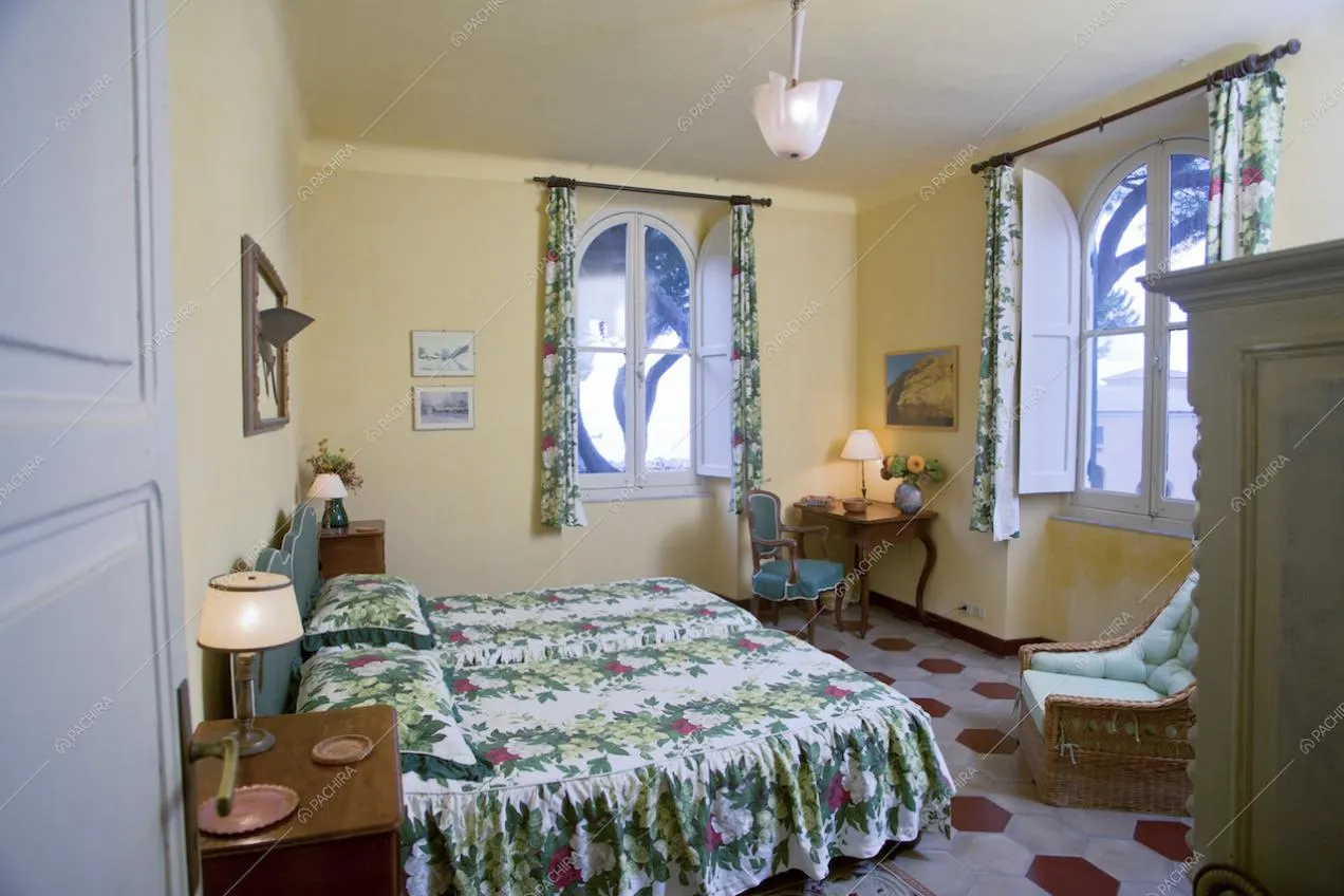 Camera da letto con letti separati, poltrona e vetrate