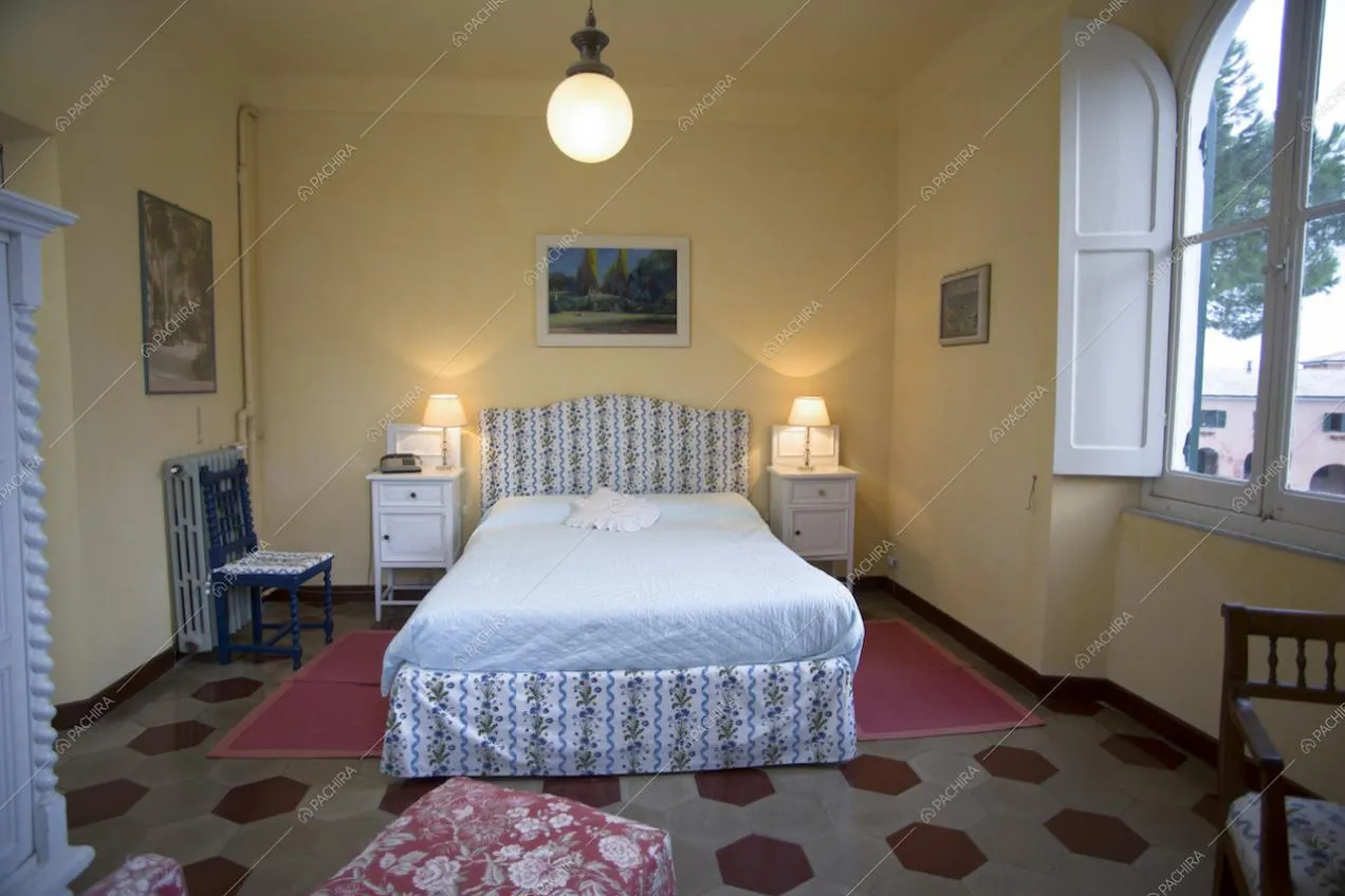 Letto matrimoniale in camera con cementine esagonali e pareti gialle