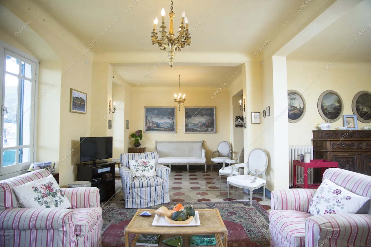 Zona living con poltrone e lampadario antico