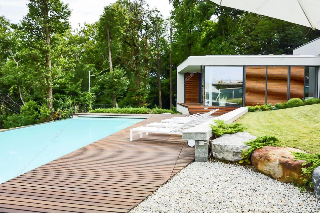 Piscina con sdraio bianche e pavimento in parquet da esterno