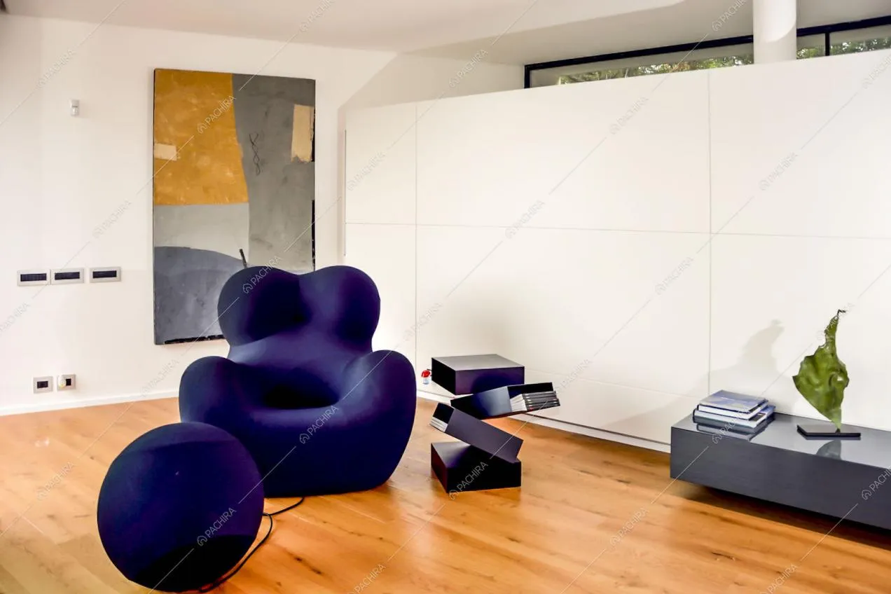 Poltrona con poggia piedi sferico e tavolino di design