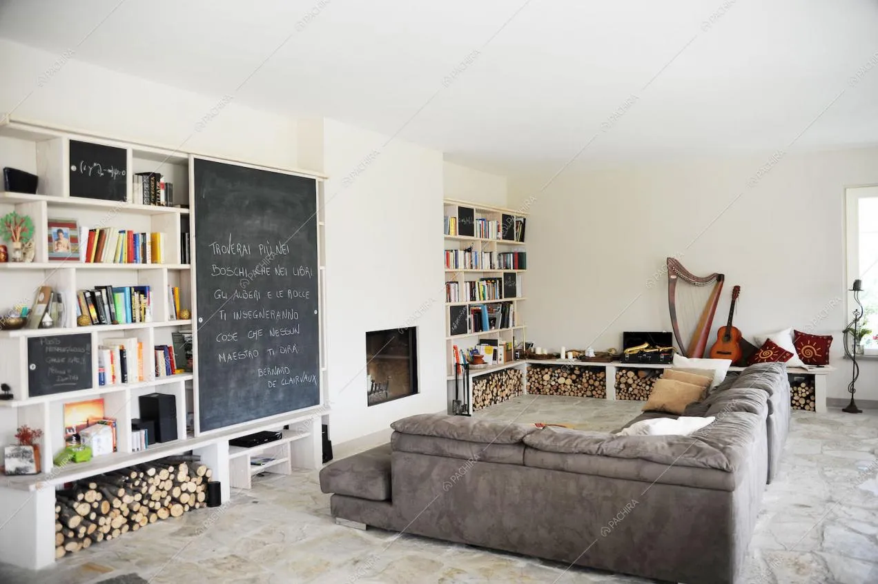 Zona living con divano e libreria a muro con lavagna in ardesia