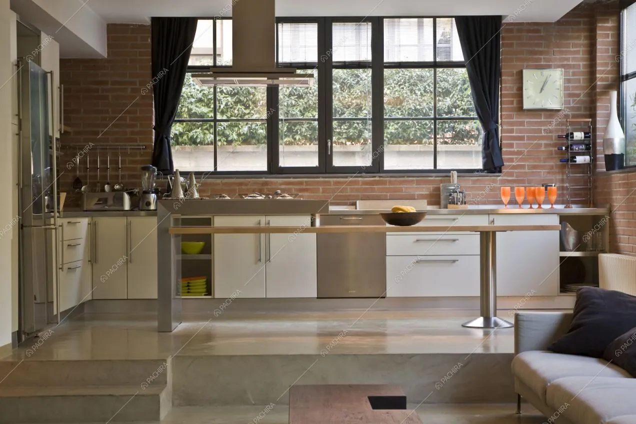 Cucina con isola e parete in mattoni a vista