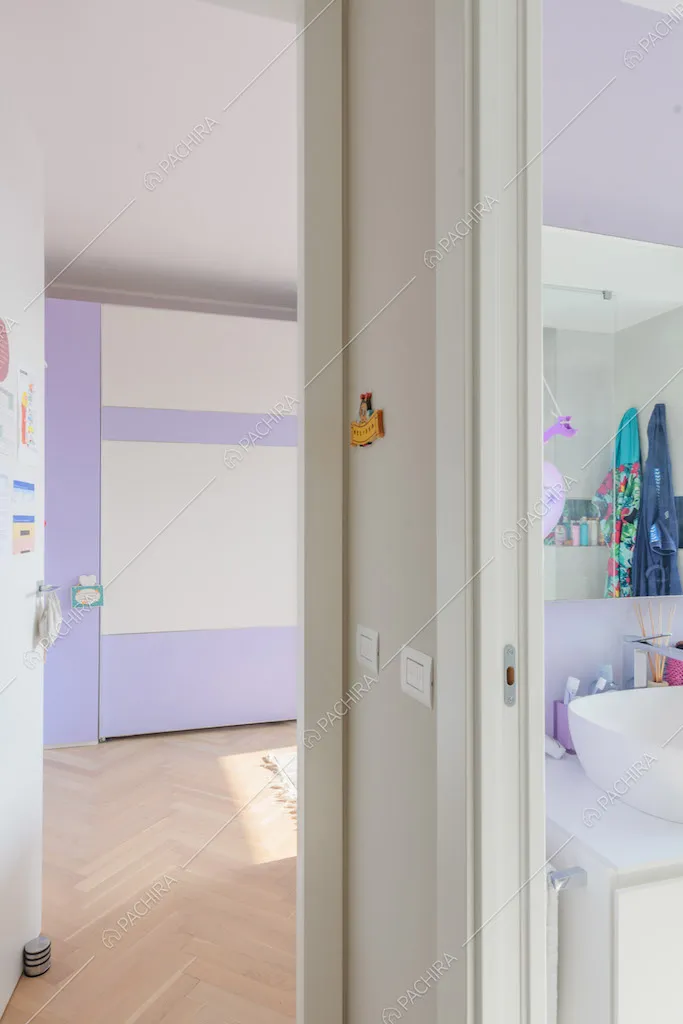 Vista sul bagno con parete lilla e sulla camera da letto dei bambini