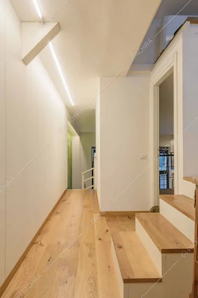 Corridoio con pavimento in parquet e pareti bianche