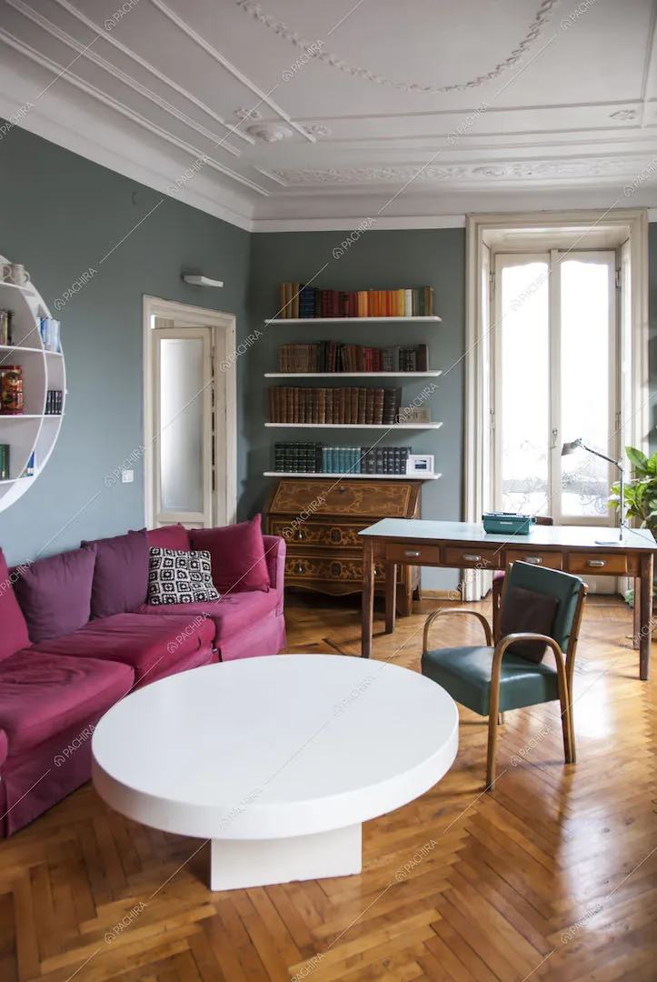 Pavimento in parquet a spina di pesce, tavolino e divano rosa scuro