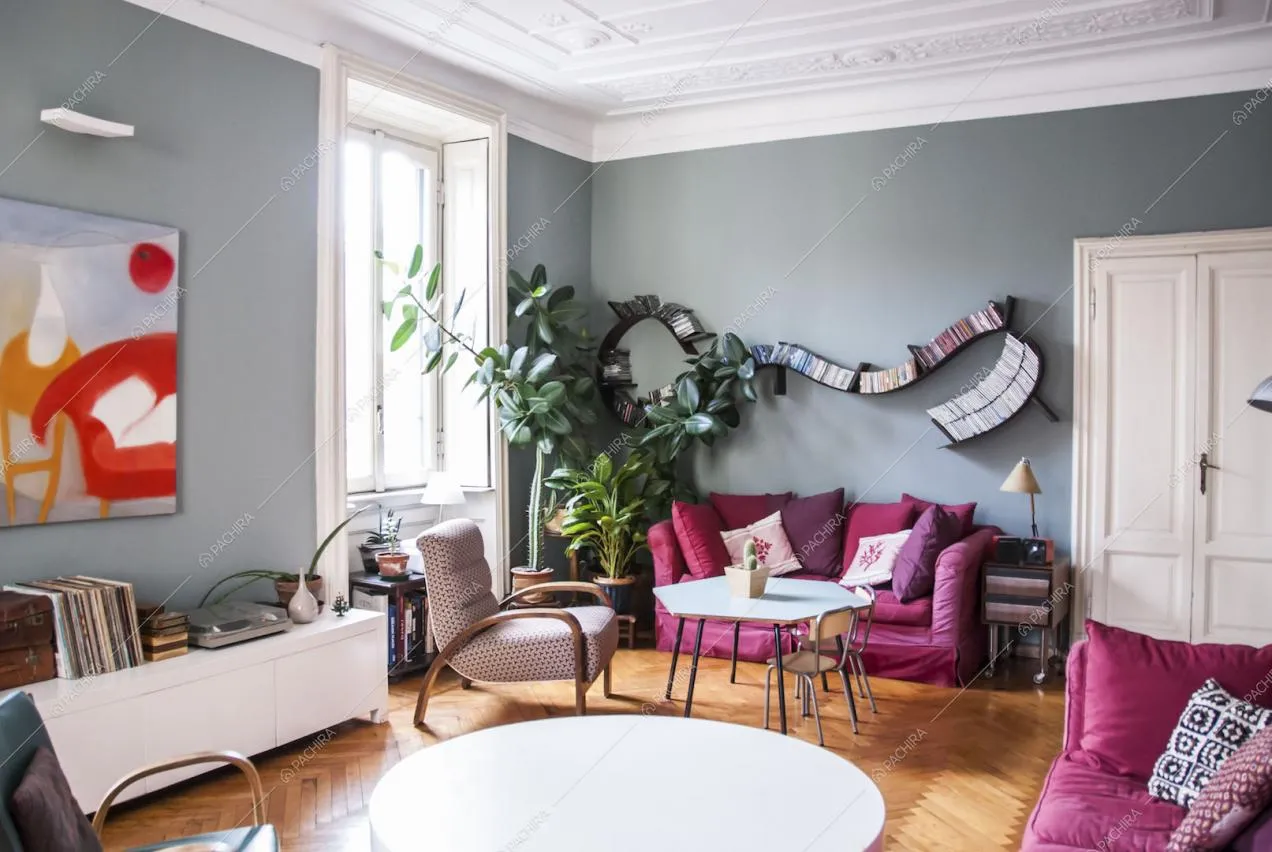 Zona living con ripiani di design, divani, poltrone vintage e tavolini
