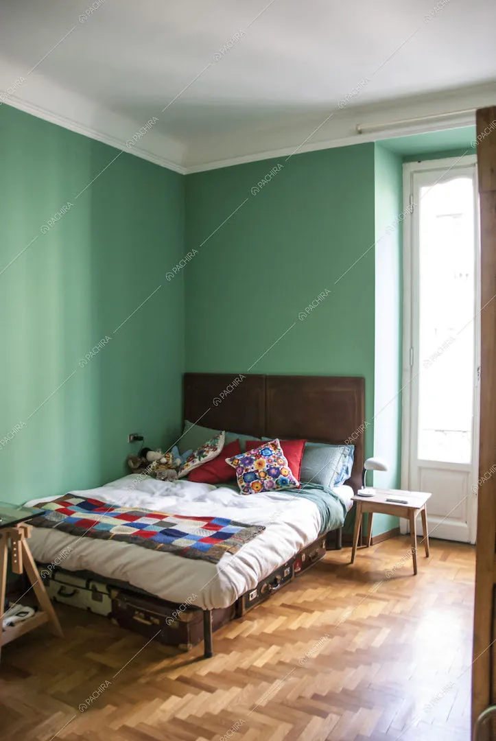 Camera da letto con pareti verdeacqua e pavimento in parquet