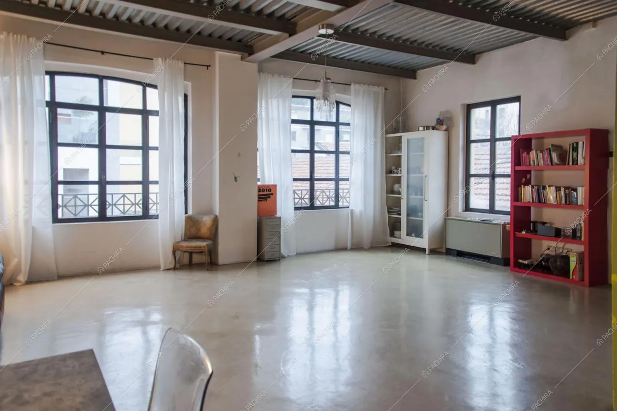 Spazio minimal con pavimento in cemento lisciato e librerie