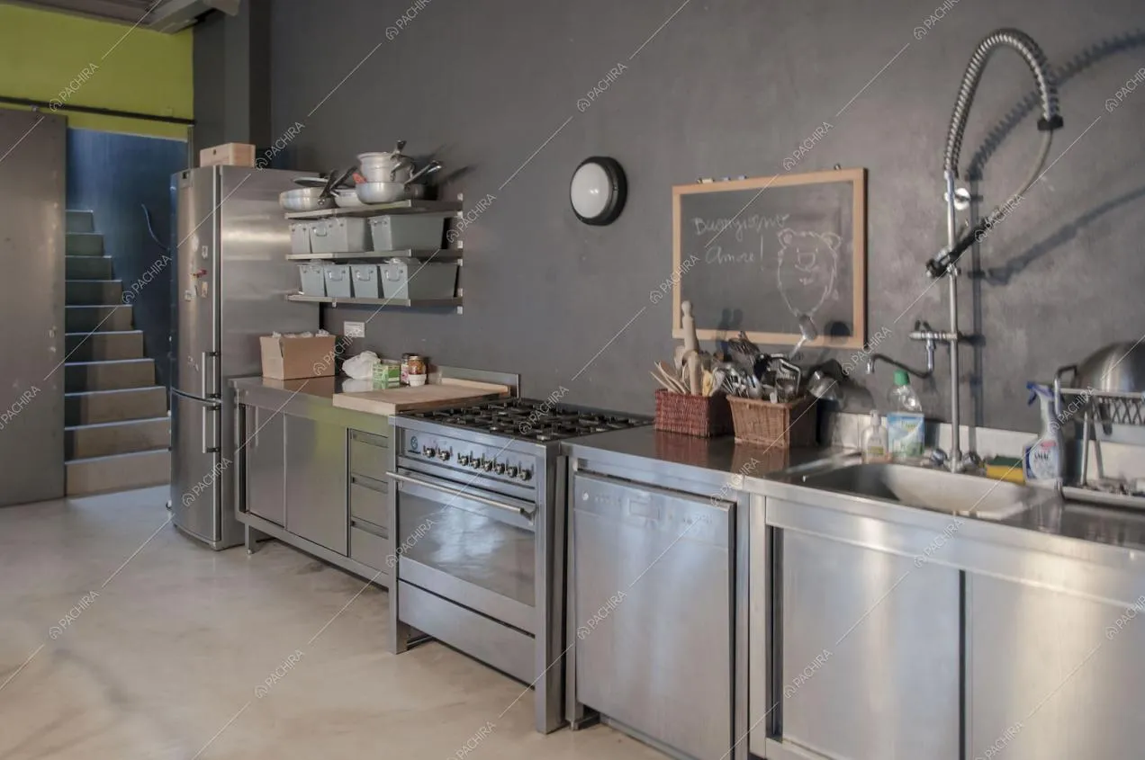 Vista sulla cucina in acciaio e scorcio su scale