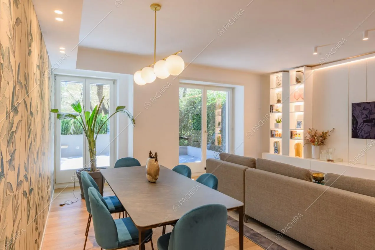 Tavolo da pranzo grigio nella zona living con pavimento in parquet e carta da parati