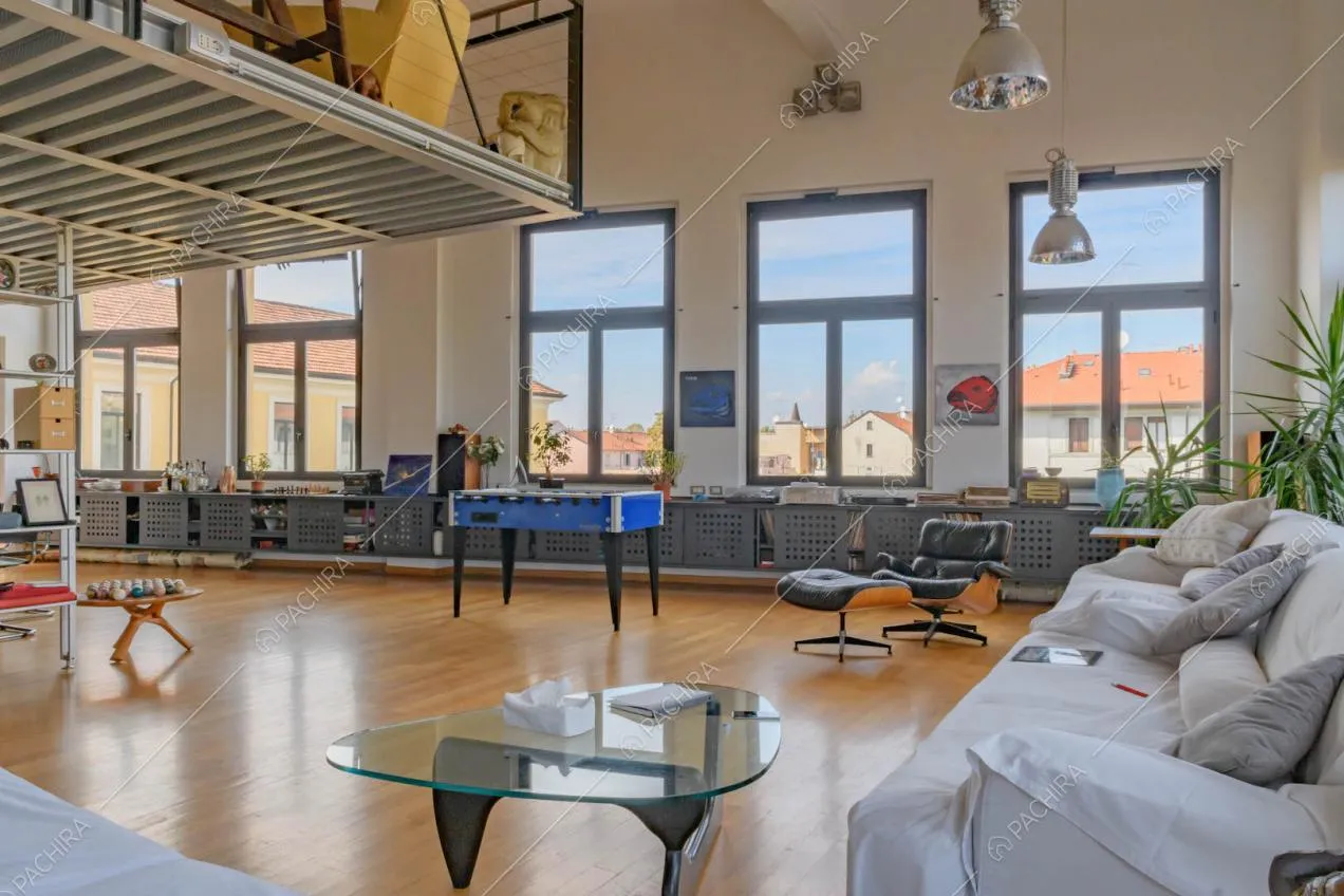 Divani bianchi nella sala con grandi vetrate e pavimento in parquet