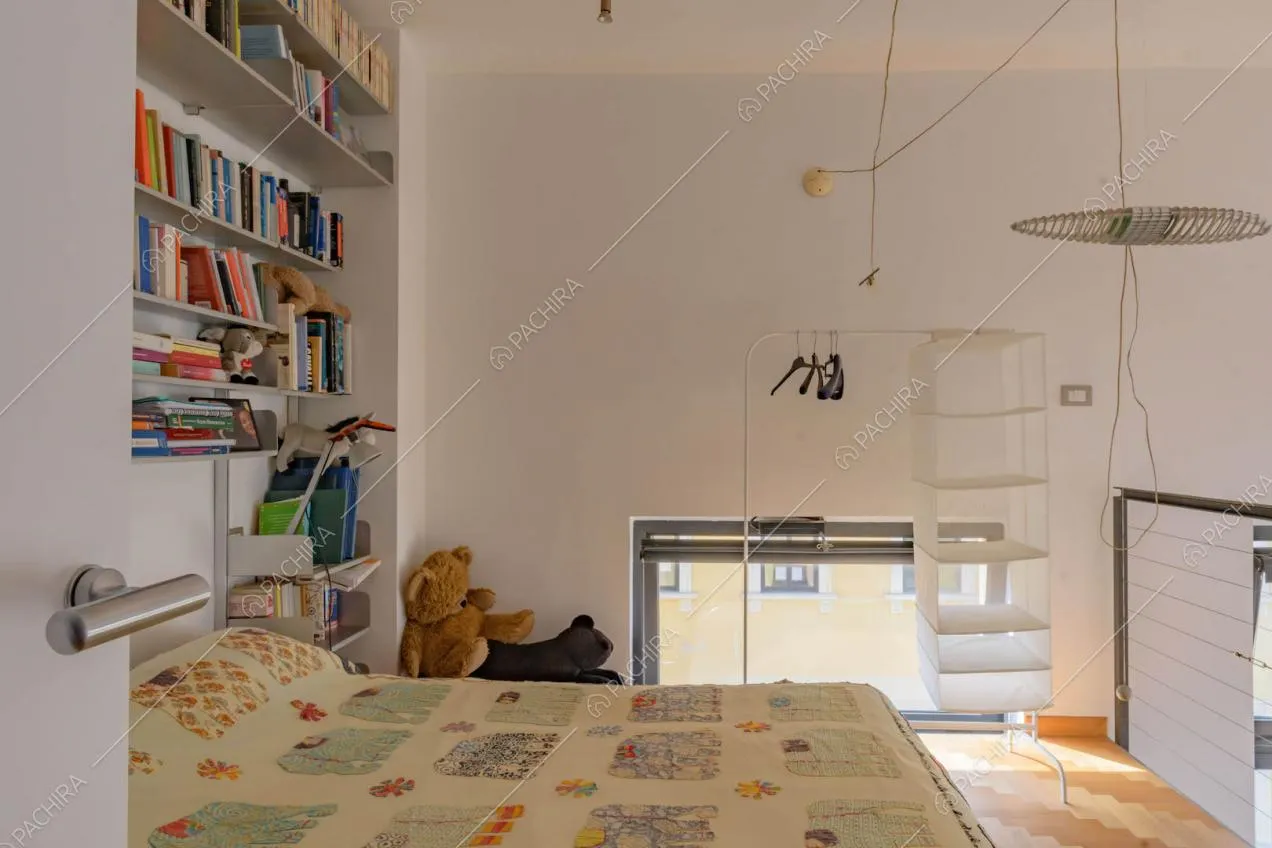 Camera da letto da bambini con pavimento in parquet e balaustra in metallo