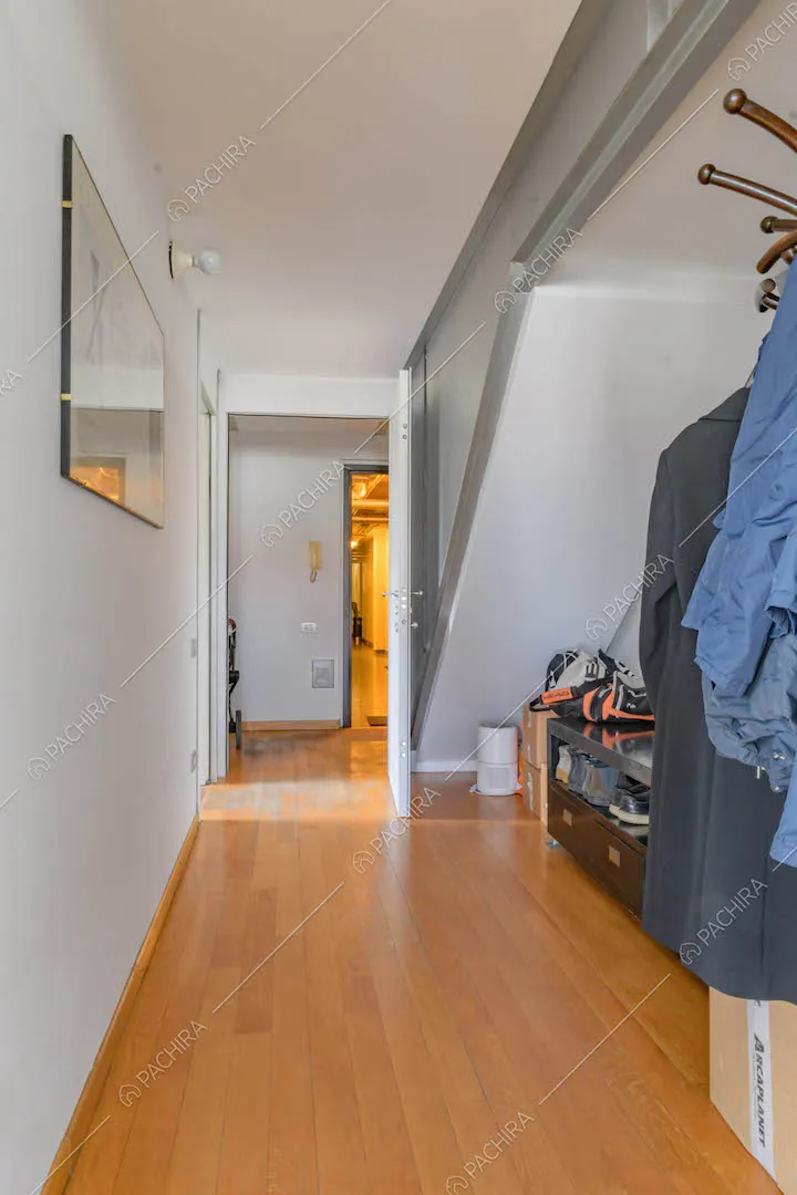 Ingresso della location pavimento in parquet, pareti bianche e scale