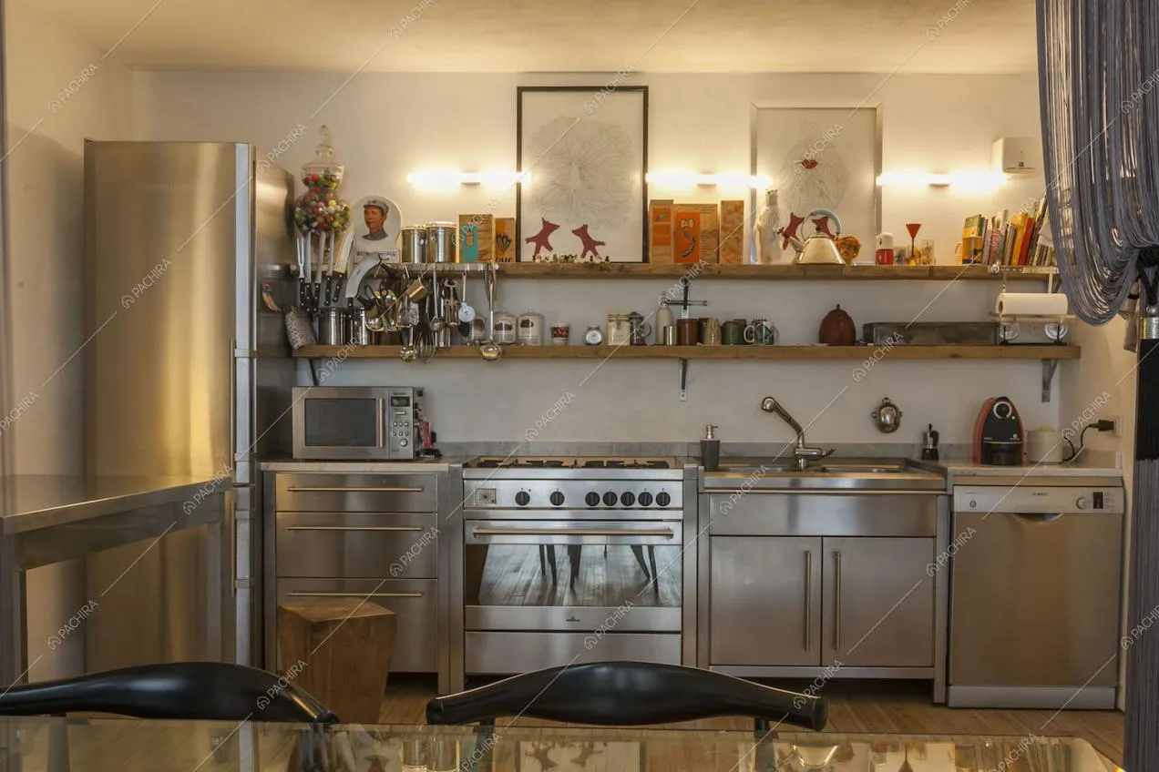 Cucina in acciaio del loft con ripiani in legno